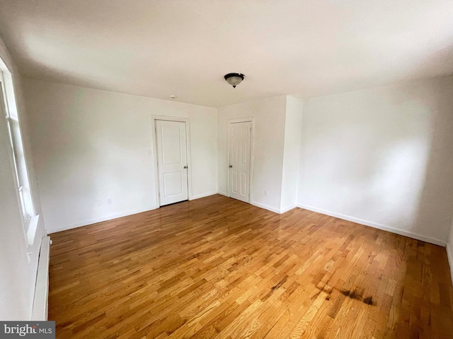 3647 N 19th St, Philadelphia, PA 19140 - spare room with wood finished floors, a baseboard heating unit, and baseboards