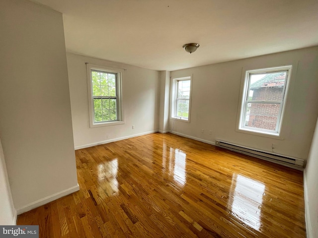 3647 N 19th St, Philadelphia, PA 19140 - empty room with a baseboard radiator, healthy amount of natural light, and hardwood / wood-style floors