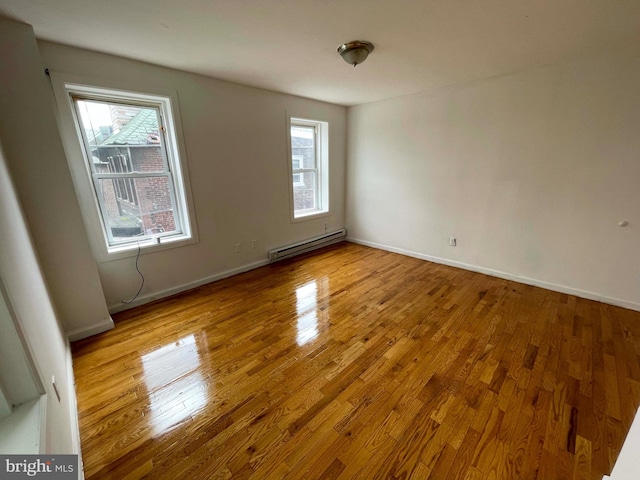 3647 N 19th St, Philadelphia, PA 19140 - spare room with a baseboard radiator, wood finished floors, and healthy amount of natural light