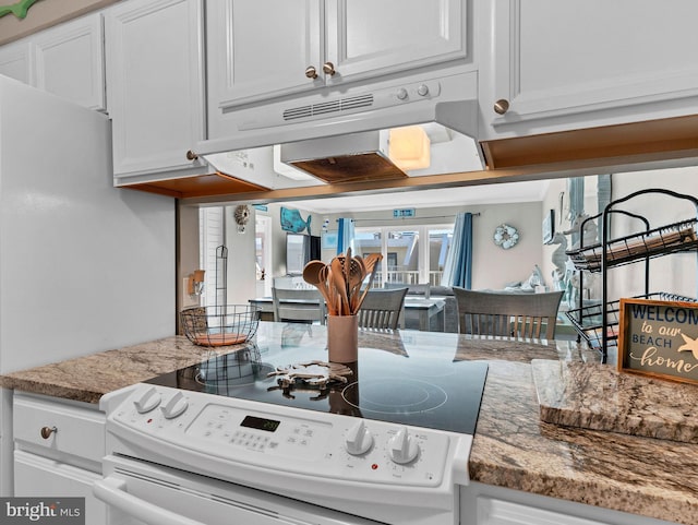 4711 Coastal Hwy Unit 538, Ocean City, MD 21842 - kitchen with white electric stove, under cabinet range hood, white cabinets, and stone counters