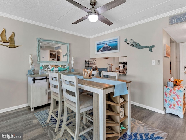 4711 Coastal Hwy Unit 538, Ocean City, MD 21842 - dining room featuring wood finished floors, a textured ceiling, ceiling fan, ornamental molding, and baseboards