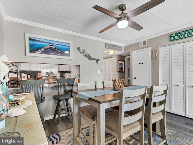 4711 Coastal Hwy Unit 538, Ocean City, MD 21842 - dining room featuring dark wood-style flooring, a textured ceiling, ornamental molding, and a ceiling fan