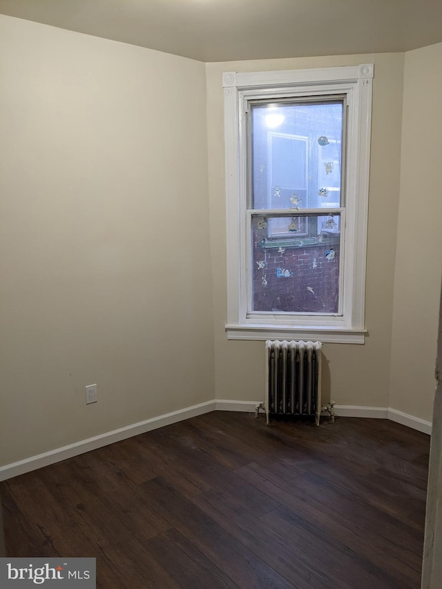 4303 N Franklin St, Philadelphia, PA 19140 - spare room with radiator, dark wood-style floors, and baseboards
