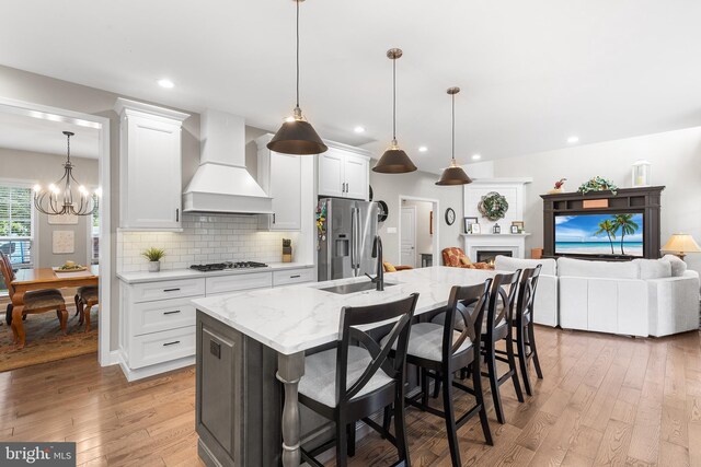 48 Avalon Ct Unit 2301, Doylestown, PA 18901 - kitchen with custom range hood, stainless steel fridge, gas stovetop, a sink, and light wood finished floors