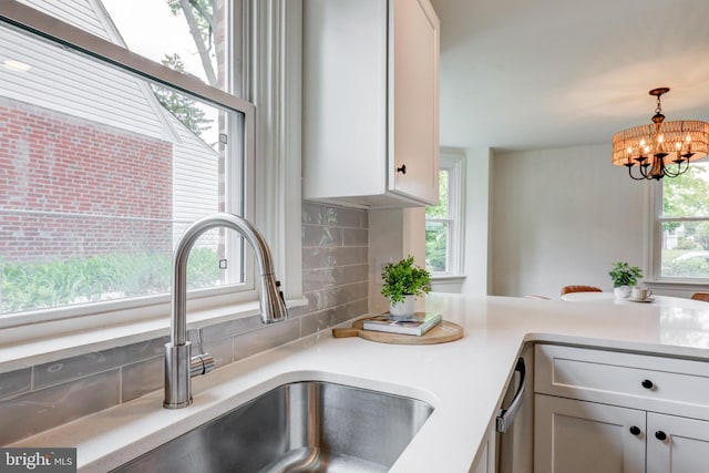 515 Devon Rd, Havertown, PA 19083 - kitchen with a sink, backsplash, light countertops, a chandelier, and hanging light fixtures