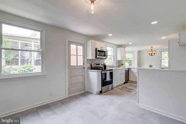 515 Devon Rd, Havertown, PA 19083 - kitchen with appliances with stainless steel finishes, a chandelier, white cabinetry, a peninsula, and recessed lighting