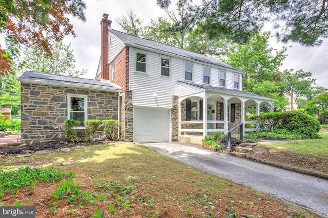 515 Devon Rd, Havertown, PA 19083 - view of front of home featuring a porch, stone siding, a chimney, driveway, and an attached garage