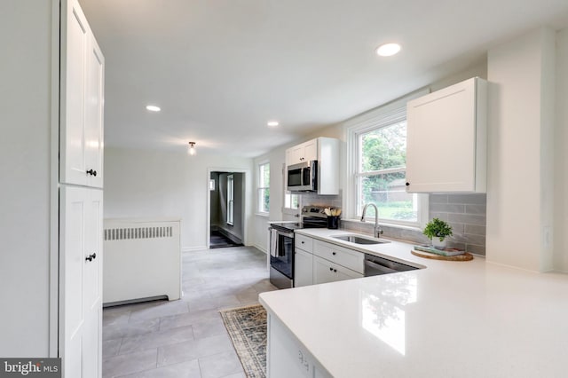 515 Devon Rd, Havertown, PA 19083 - kitchen featuring appliances with stainless steel finishes, radiator heating unit, a sink, tasteful backsplash, and recessed lighting