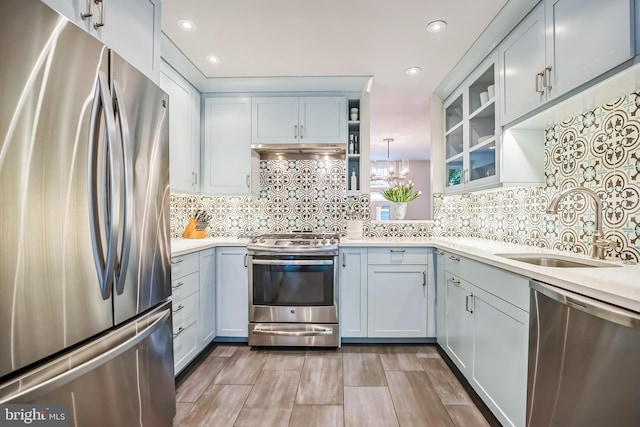 510 Pine St, Philadelphia, PA 19106 - kitchen featuring appliances with stainless steel finishes, a sink, light countertops, glass insert cabinets, and decorative backsplash