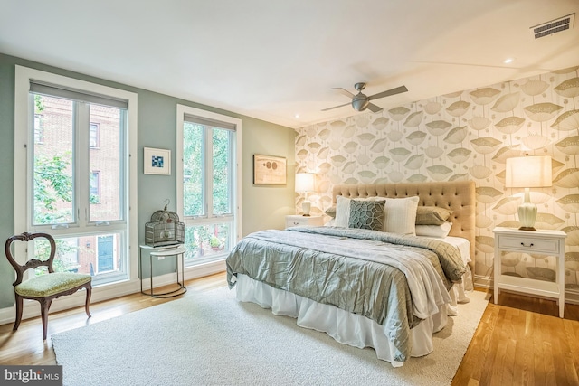 510 Pine St, Philadelphia, PA 19106 - bedroom with an accent wall, baseboards, wallpapered walls, wood finished floors, and ceiling fan