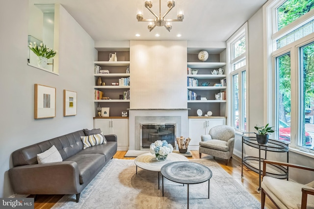 510 Pine St, Philadelphia, PA 19106 - living area with a chandelier, wood finished floors, a glass covered fireplace, built in shelves, and recessed lighting