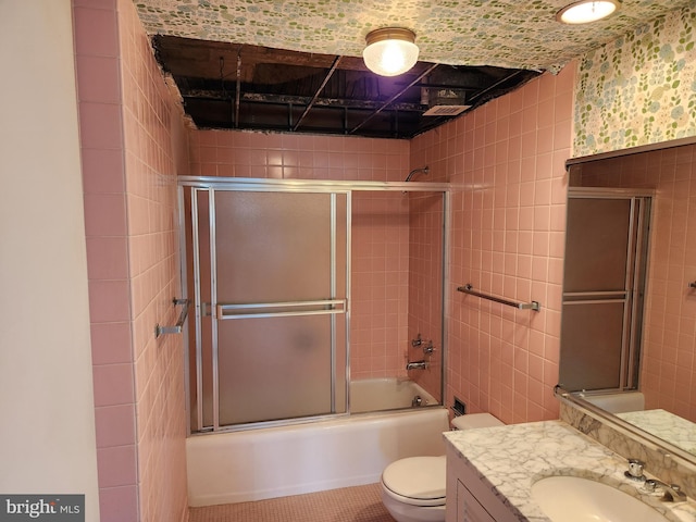 7121 Park Heights Ave Unit 206, Baltimore, MD 21215 - bathroom with tile walls, toilet, vanity, and shower / bath combination with glass door