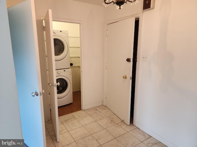 7121 Park Heights Ave Unit 206, Baltimore, MD 21215 - washroom featuring stacked washer / drying machine, baseboards, and a chandelier