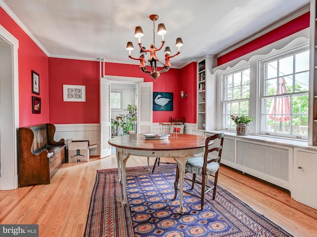 326 Saint Dunstans Rd, Baltimore, MD 21212 - dining space with radiator, a chandelier, crown molding, wood finished floors, and wainscoting