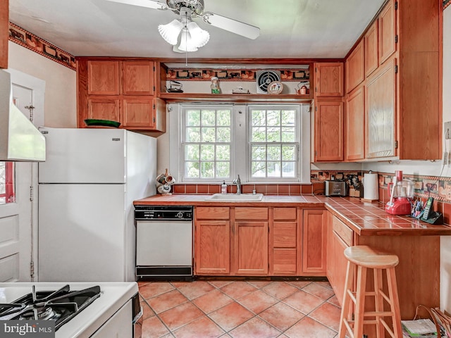 326 Saint Dunstans Rd, Baltimore, MD 21212 - kitchen featuring tile counters, white appliances, a sink, ceiling fan, and light tile patterned flooring