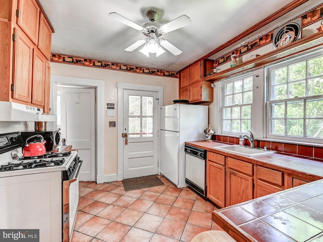 326 Saint Dunstans Rd, Baltimore, MD 21212 - kitchen with white appliances, under cabinet range hood, a sink, tile counters, and light tile patterned floors