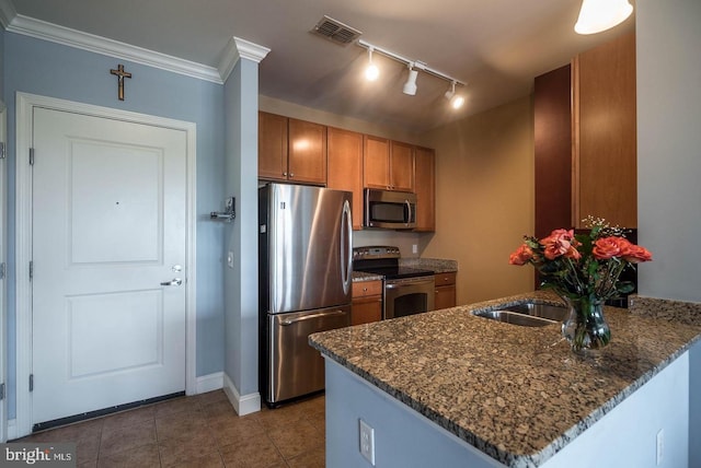 1391 Pennsylvania Ave SE Unit 471, Washington, DC 20003 - kitchen featuring stainless steel appliances, a peninsula, brown cabinetry, rail lighting, and tile patterned flooring