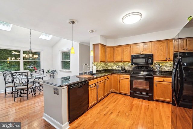 4270 Deborah Ct, Mount Airy, MD 21771 - kitchen with black appliances, a sink, a skylight, brown cabinetry, and vaulted ceiling