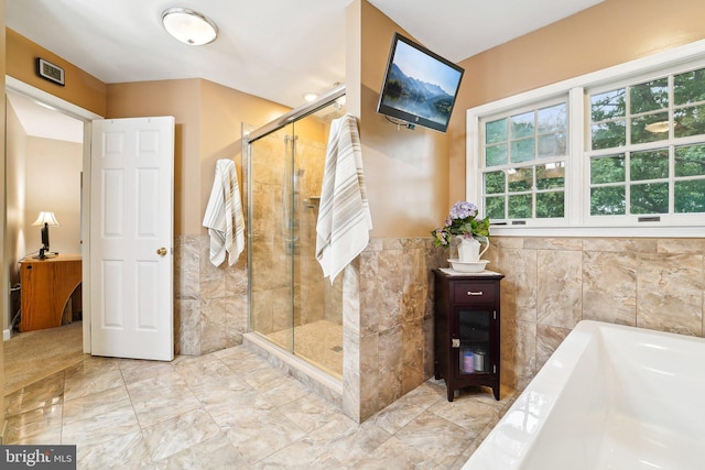 4270 Deborah Ct, Mount Airy, MD 21771 - bathroom featuring a garden tub, a stall shower, tile walls, wainscoting, and marble finish floors
