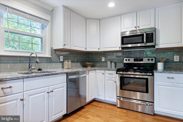 6600 Rockleigh Way, Alexandria, VA 22315 - kitchen featuring appliances with stainless steel finishes, a sink, white cabinets, tasteful backsplash, and crown molding