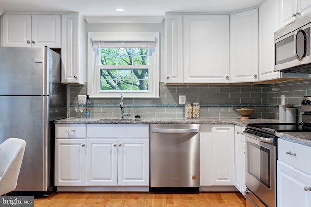 6600 Rockleigh Way, Alexandria, VA 22315 - kitchen with stainless steel appliances, a sink, ornamental molding, white cabinetry, and decorative backsplash