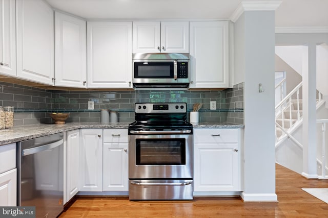 6600 Rockleigh Way, Alexandria, VA 22315 - kitchen featuring appliances with stainless steel finishes, ornamental molding, light wood finished floors, decorative backsplash, and white cabinetry