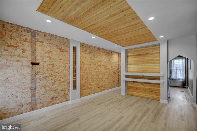 918 Spring St, Reading, PA 19604 - unfurnished room with radiator, wood ceiling, wood finished floors, recessed lighting, and brick wall
