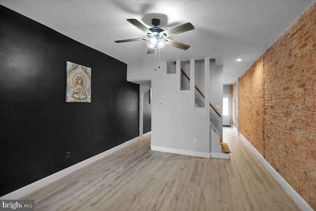 918 Spring St, Reading, PA 19604 - unfurnished room featuring brick wall, ceiling fan, wood finished floors, baseboards, and stairway