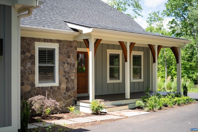 329 Carrsbrook Dr, Charlottesville, VA 22901 - view of exterior entry with roof with shingles, stone siding, a porch, and board and batten siding