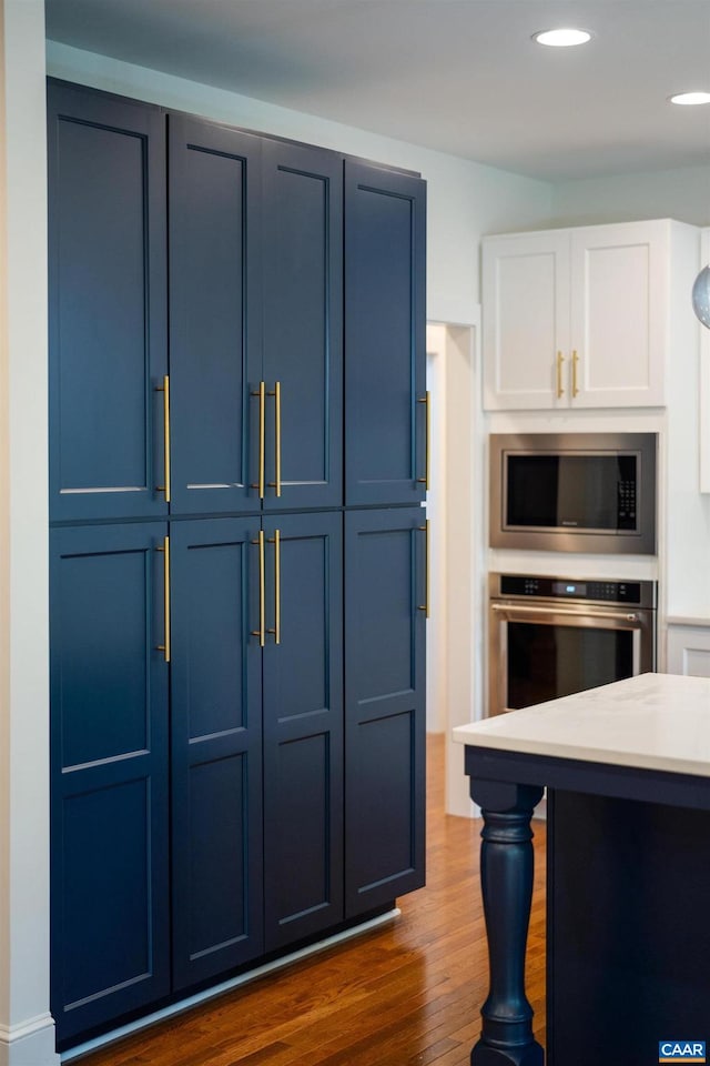 329 Carrsbrook Dr, Charlottesville, VA 22901 - kitchen featuring stainless steel appliances, blue cabinets, dark wood-style floors, recessed lighting, and white cabinets