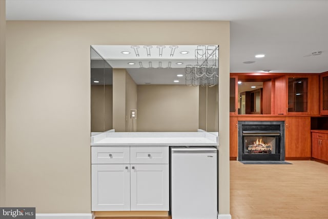 2300 Yvonnes Way, Dunn Loring, VA 22027 - kitchen featuring fridge, light wood-type flooring, a fireplace with flush hearth, white cabinetry, and light countertops