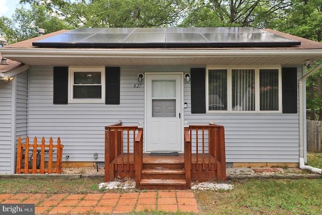 827 Rogers St, Lanoka Harbor, NJ 08734 - view of front facade featuring roof mounted solar panels and covered porch