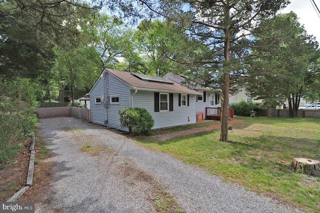 827 Rogers St, Lanoka Harbor, NJ 08734 - view of front of property featuring gravel driveway, roof mounted solar panels, roof with shingles, and a wooden deck