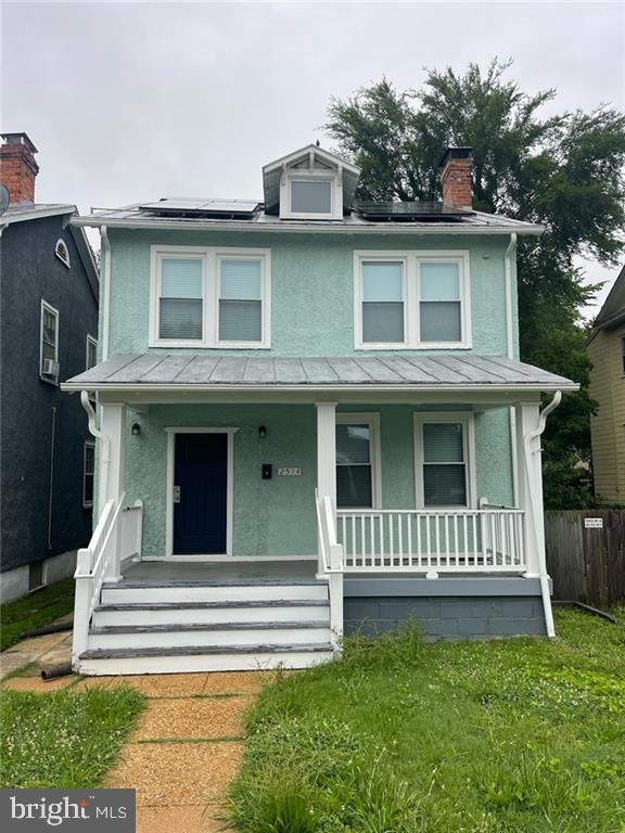 2514 4th Ave, Richmond, VA 23222 - traditional style home featuring a standing seam roof, covered porch, stucco siding, and solar panels