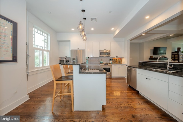 206 Price Ave Unit 2, Narberth, PA 19072 - kitchen featuring appliances with stainless steel finishes, white cabinets, a sink, a kitchen breakfast bar, and decorative light fixtures