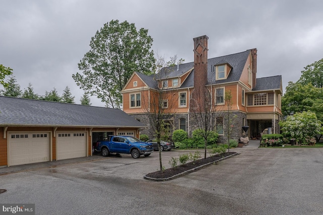 206 Price Ave Unit 2, Narberth, PA 19072 - view of front facade with stone siding, a chimney, a garage, and asphalt driveway