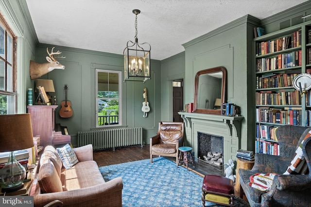 101 Warren Ave, Sewell, NJ 08080 - sitting room with radiator heating unit, ornamental molding, wood finished floors, a chandelier, and a fireplace with flush hearth