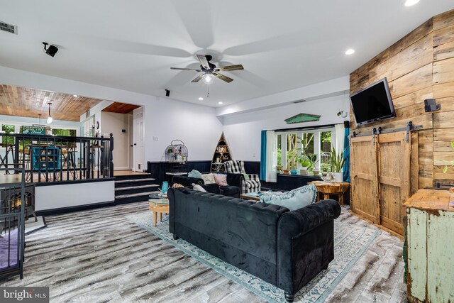 7001 Locust Ct, Owings, MD 20736 - living area with wood finished floors, a ceiling fan, recessed lighting, wood walls, and a barn door