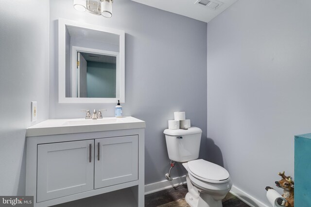 7001 Locust Ct, Owings, MD 20736 - half bathroom featuring toilet, baseboards, vanity, and wood finished floors