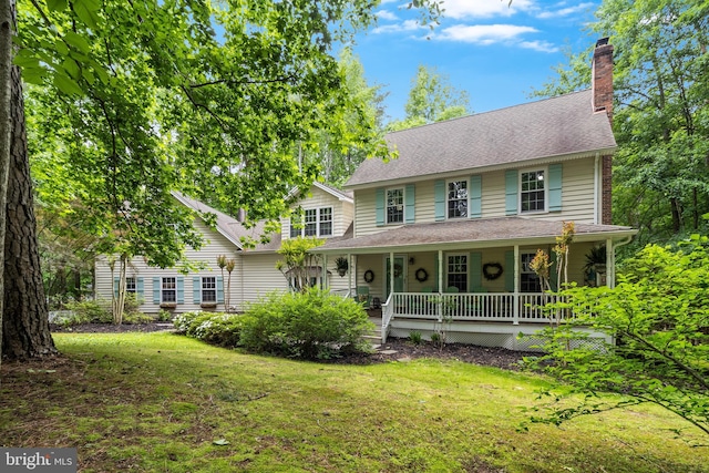 7001 Locust Ct, Owings, MD 20736 - view of front facade featuring covered porch, a front lawn, a chimney, and roof with shingles