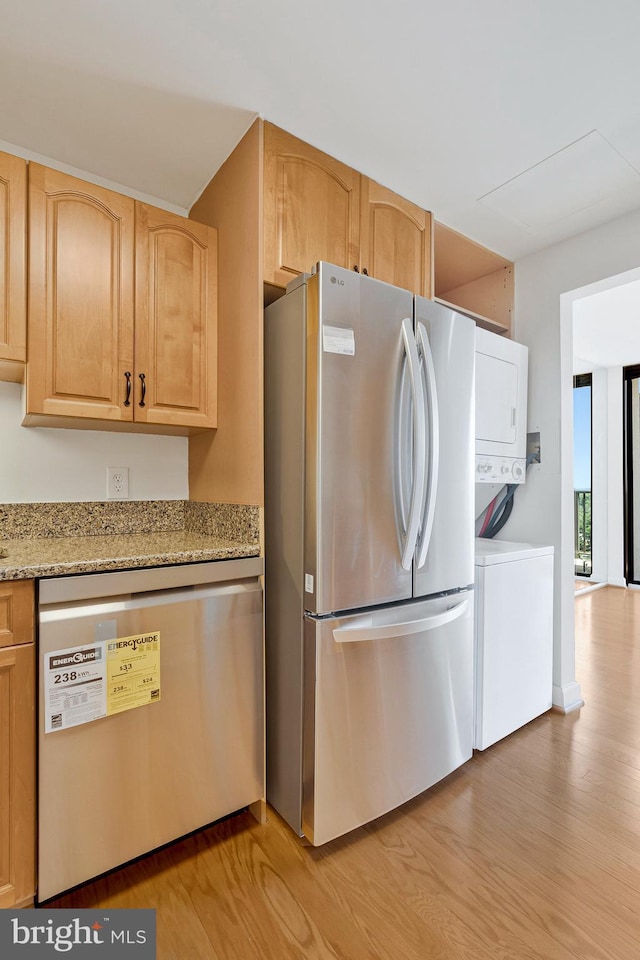 6800 Fleetwood Rd Unit 1219, Mclean, VA 22101 - kitchen with appliances with stainless steel finishes, stacked washer / dryer, light wood-style flooring, light brown cabinets, and light stone countertops