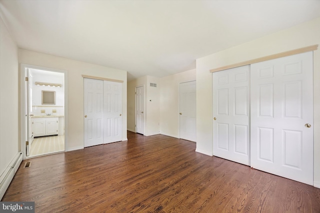 151 W Meade St, Philadelphia, PA 19118 - unfurnished bedroom with multiple closets, dark wood-style flooring, a baseboard heating unit, and baseboards
