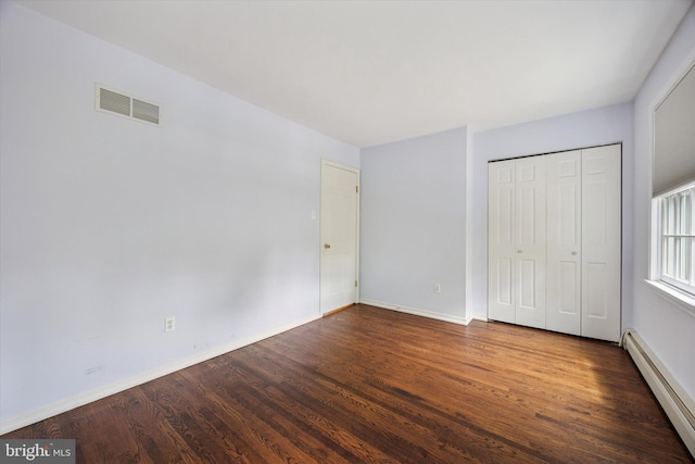 151 W Meade St, Philadelphia, PA 19118 - unfurnished bedroom with a baseboard heating unit, wood finished floors, baseboards, and a closet