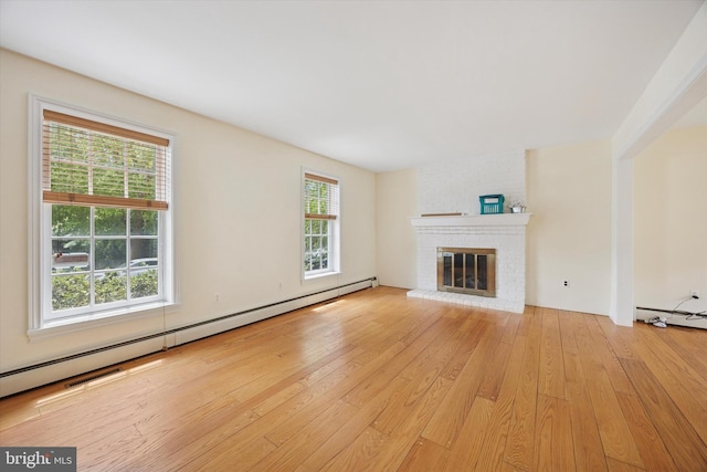 151 W Meade St, Philadelphia, PA 19118 - unfurnished living room with a baseboard radiator, light wood-style flooring, and a brick fireplace