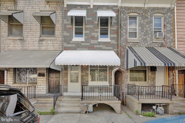 1120 N 10th St, Reading, PA 19604 - view of property featuring stone siding, cooling unit, and covered porch