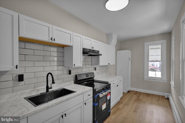 1120 N 10th St, Reading, PA 19604 - kitchen featuring electric range oven, a sink, under cabinet range hood, white cabinetry, and decorative backsplash