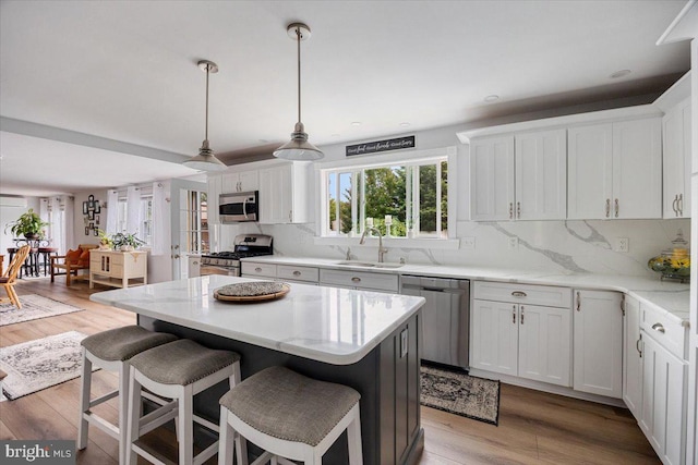 209 Burlington Ave, Voorhees, NJ 08043 - kitchen featuring appliances with stainless steel finishes, a sink, a breakfast bar, and white cabinetry