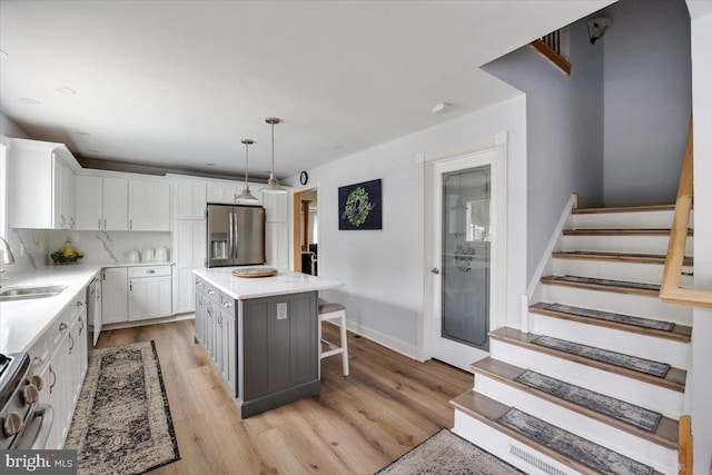 209 Burlington Ave, Voorhees, NJ 08043 - kitchen with appliances with stainless steel finishes, white cabinetry, a sink, a kitchen breakfast bar, and light countertops