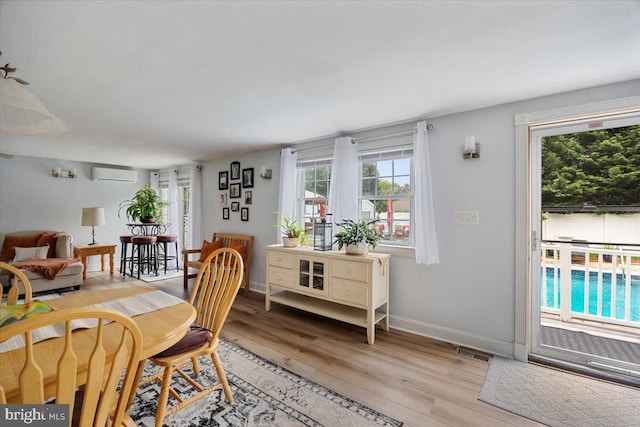 209 Burlington Ave, Voorhees, NJ 08043 - dining area with a wall mounted AC, light wood-style floors, and baseboards