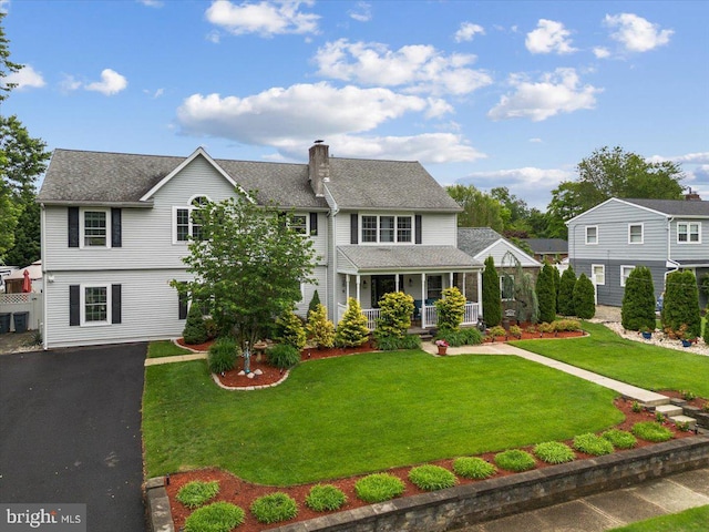 209 Burlington Ave, Voorhees, NJ 08043 - view of front of house with covered porch, a chimney, a front yard, and asphalt driveway